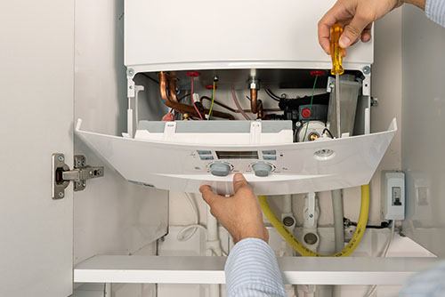 Heating technician repairing a residential boiler in Palo Alto