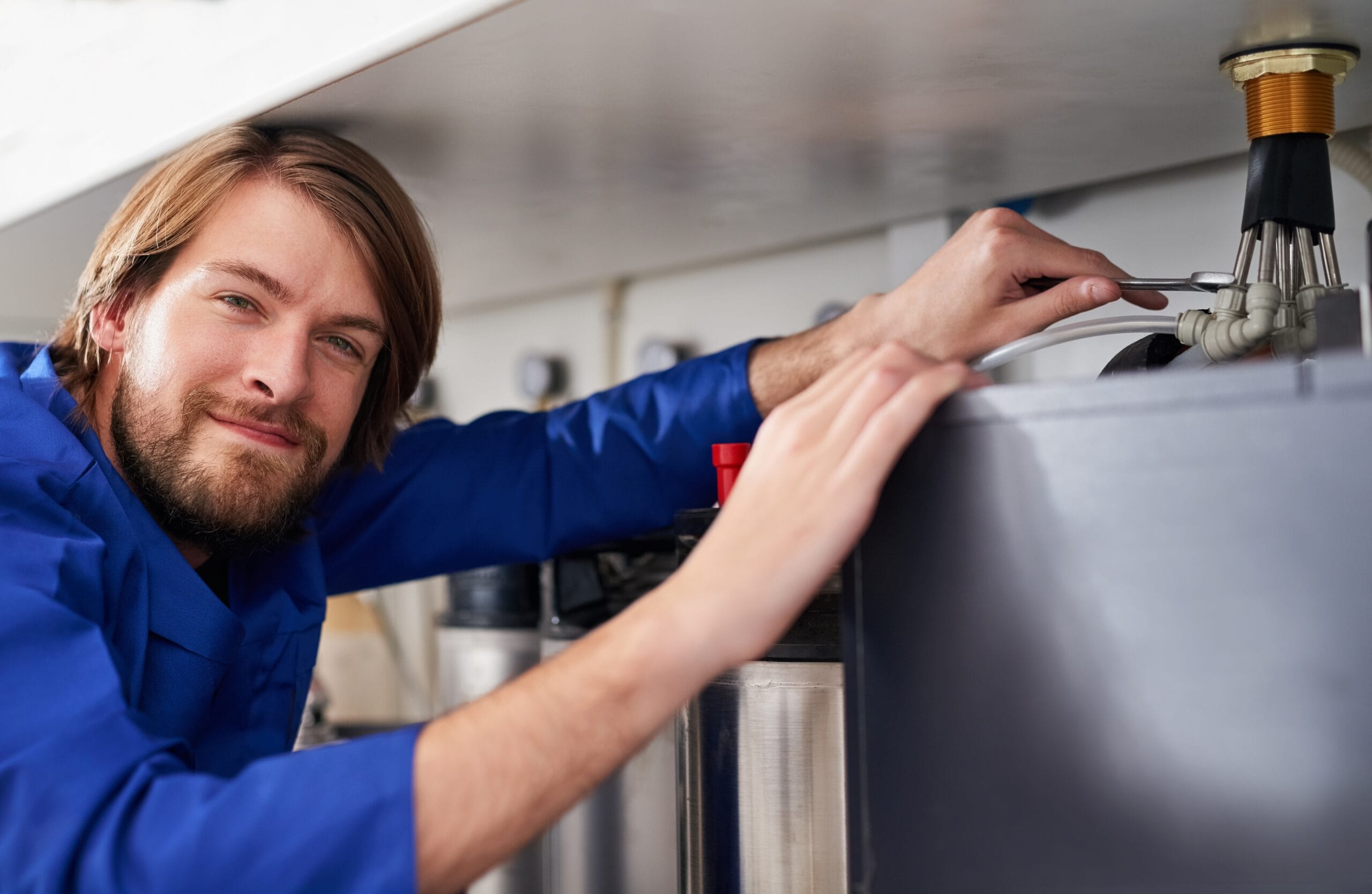 Technician servicing a residential water heater tank in Palo Alto